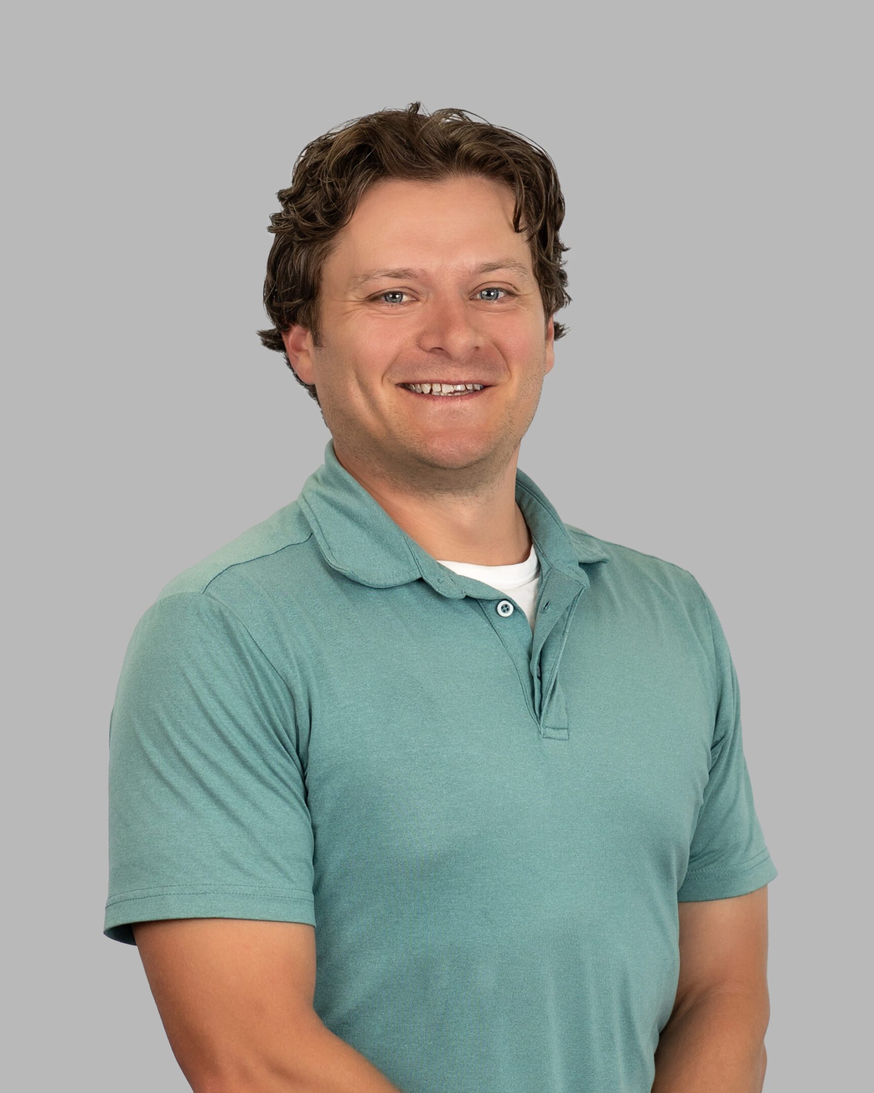 A man in a green shirt is smiling.