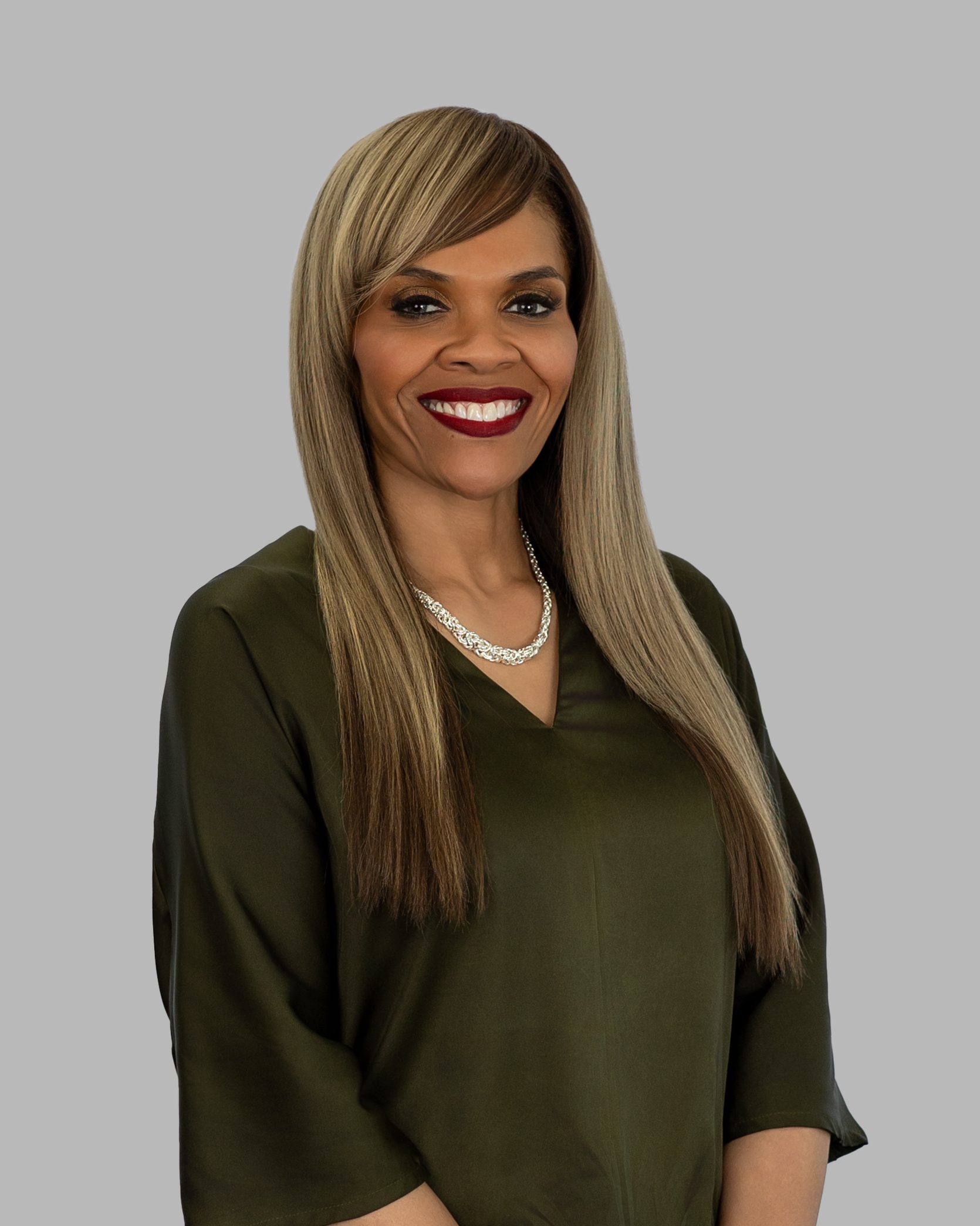 A woman with long blonde hair wearing a green shirt.