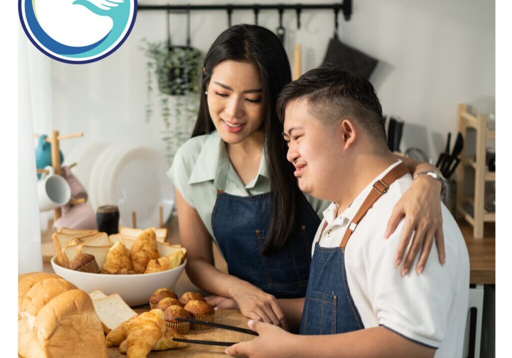 A man and woman in aprons cutting bread.